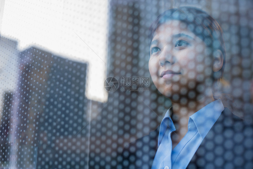 商业女商务人士透过窗外看望 在玻璃上看到城市的反光人士女性个性公司监视衣冠水平活力微笑头肩图片