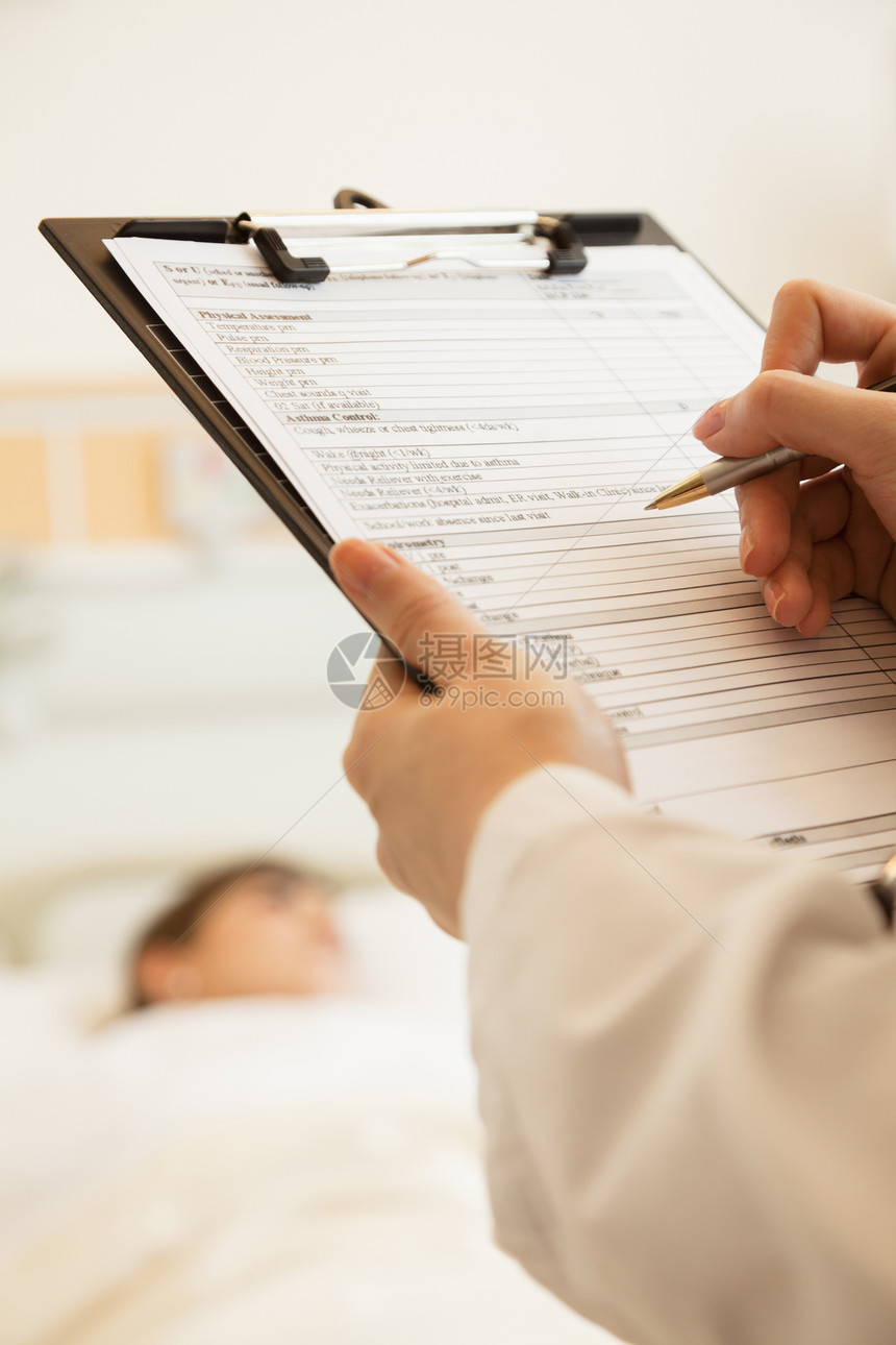 医生在医疗病历上写了近距离文章 病人躺在医院的床上 背着背景监视病房保健摄影医学部位人体工作服疾病写作图片