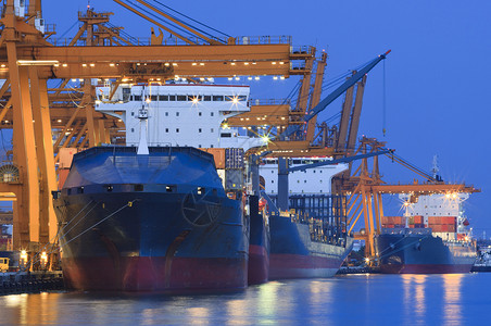 在美丽的暮色中 有重型起重机的造船厂贸易蓝色商业出口油船货运码头船运支撑油轮背景图片