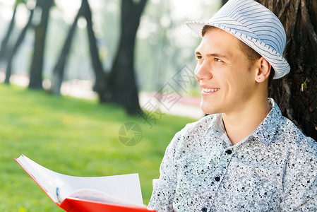年轻人在读一本书知识男性闲暇公园青年学士学校班级学习文学幸福高清图片素材