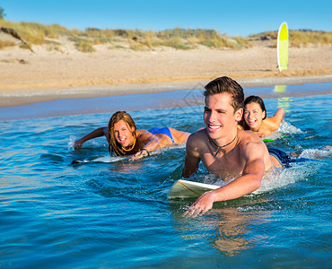 冲浪少年少年冲浪者男孩与女孩游泳游上冲浪板天空微笑青少年团队海洋假期支撑金发幸福享受背景