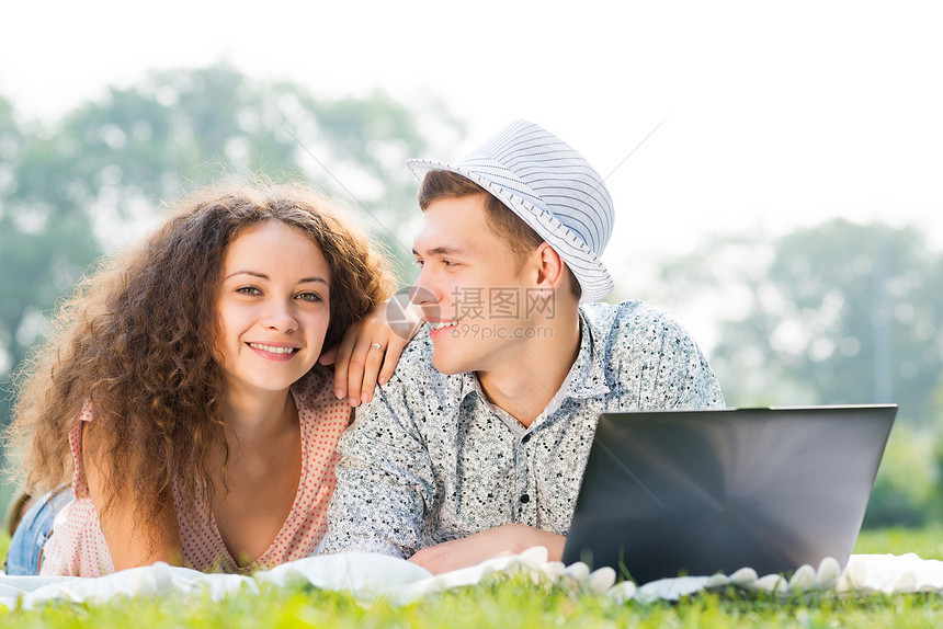一对夫妇一起躺在公园里 带着笔记本电脑姿势网络幸福快乐男人青年互联网乐趣喜悦成年人图片