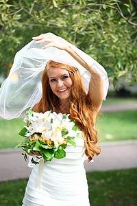 穿着婚纱的美丽红发新娘花束裙子婚礼女孩礼服女性公园花朵幸福微笑青年高清图片素材