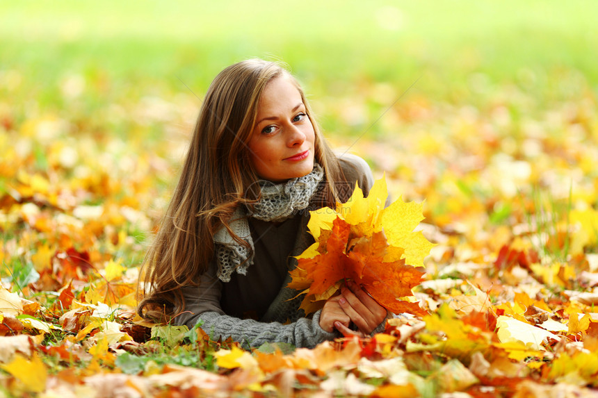 秋叶中的妇女脚尖女性幸福头发乐趣眼睛季节女孩成人微笑感恩图片