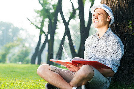 年轻人在读一本书学士成人中学公园大学学校教育男性学生闲暇脸高清图片素材