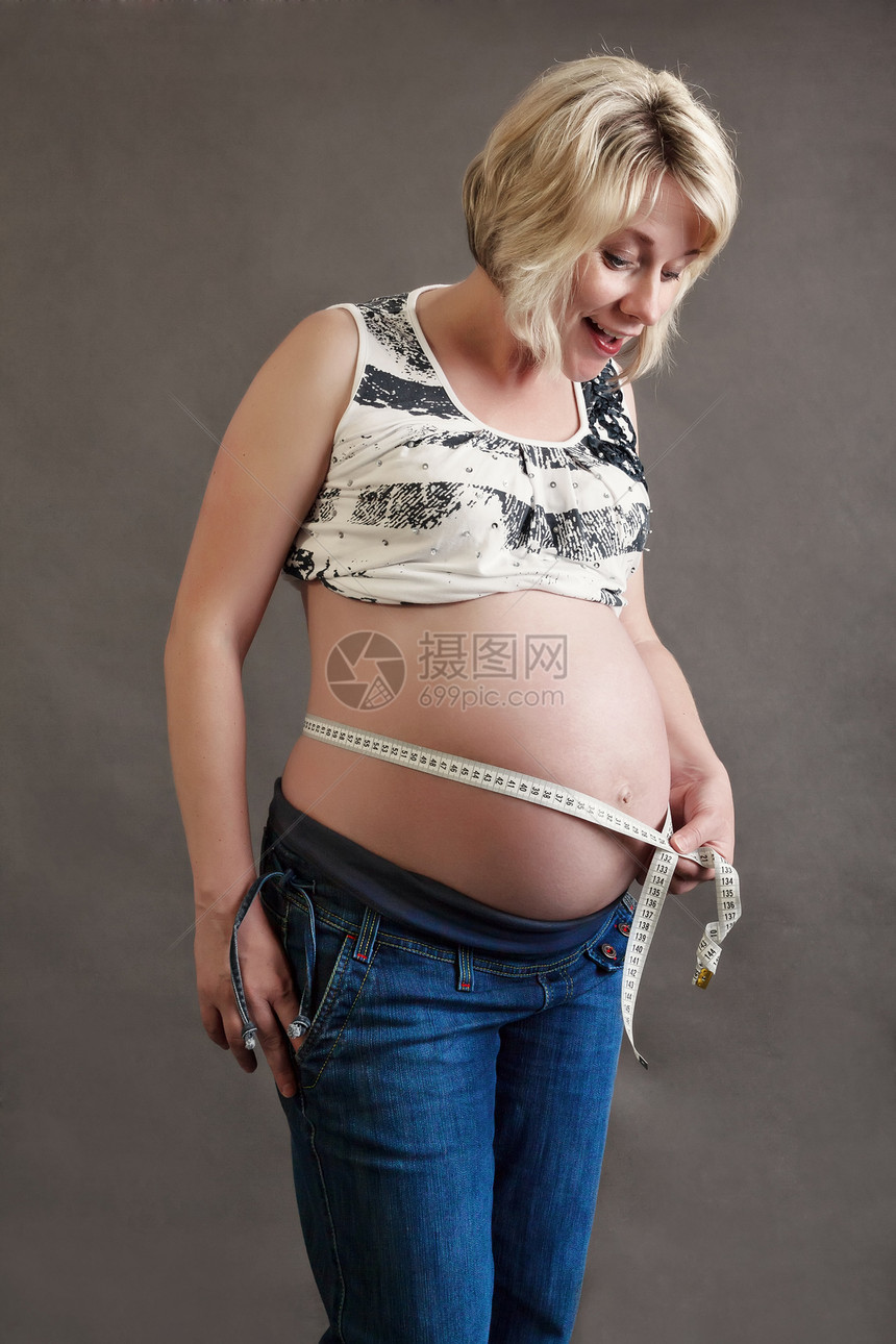 美丽的孕妇小量地测量其肚子的大小女士女孩婴儿育儿女性母性微笑快乐生活怀孕图片