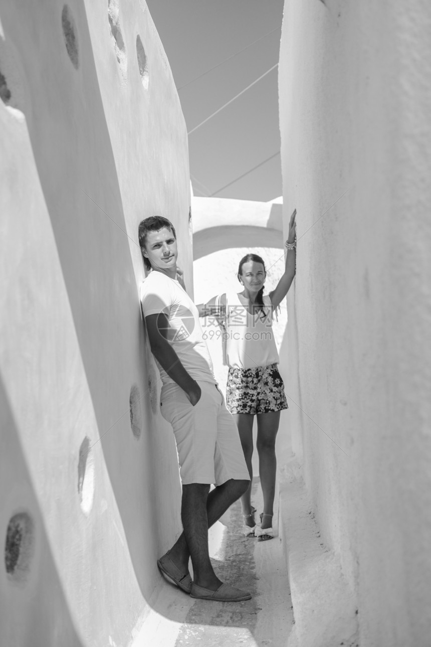 年轻夫妇在希腊圣托里尼岛的老希腊村散步商场传统楼梯女孩历史性街道村庄脚步房子建筑图片