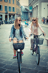 两个漂亮的金发美女 骑自行车购物女性女士微笑美丽街道幸福友谊金发女郎城市朋友们背景图片