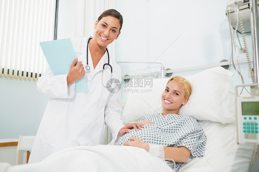 女产科医生与微笑着的孕妇交谈图片
