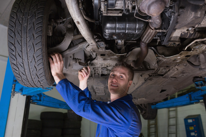 在汽车下工作的汽车机械工修理工男人修复职业汽修机械工程师幸福检查男性图片