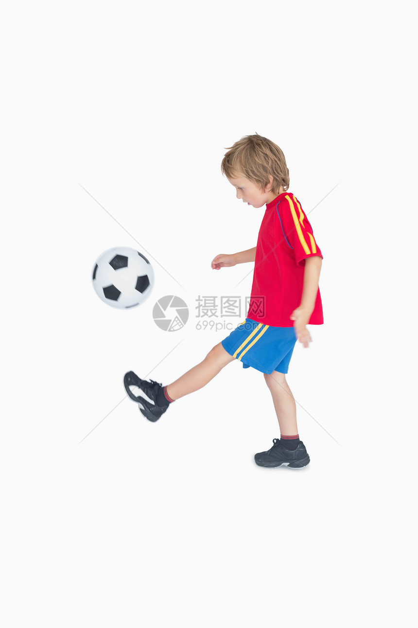 小男孩踢足球的侧边景色图片