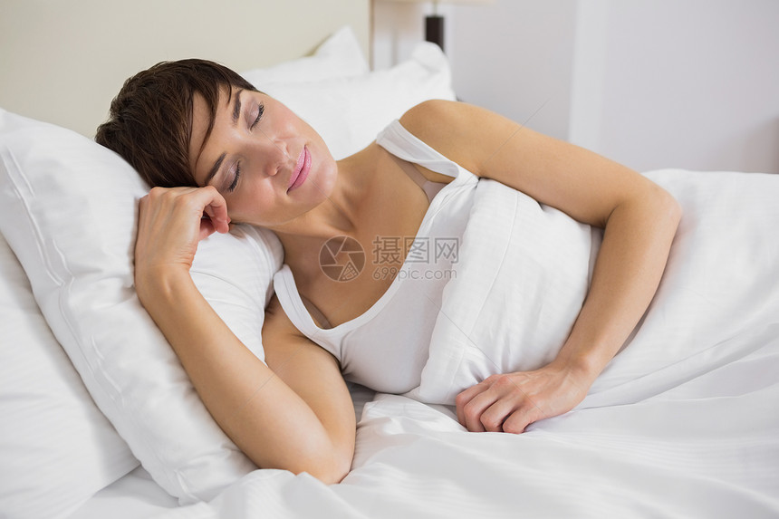 睡在床上的有吸引力的女人羽绒被短发卧室枕头说谎女性睡衣就寝棕色时间图片