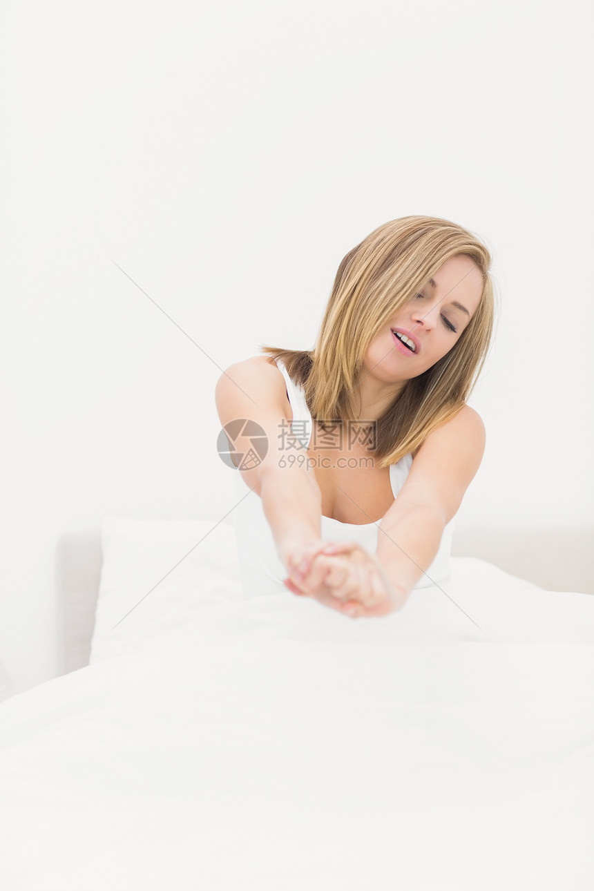 沉睡的女人在床上伸展图片