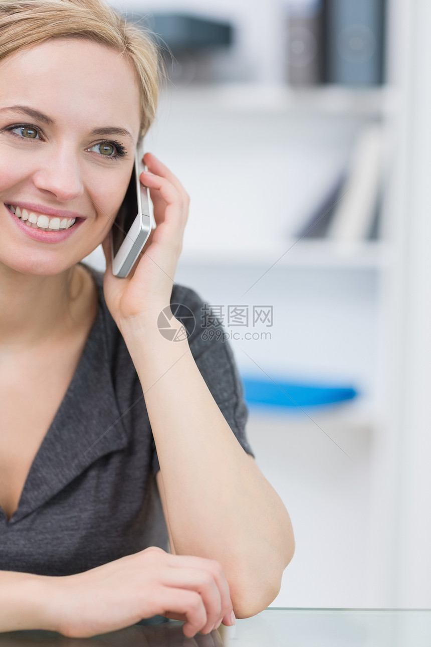 利用手机特写微笑的女商业妇女图片