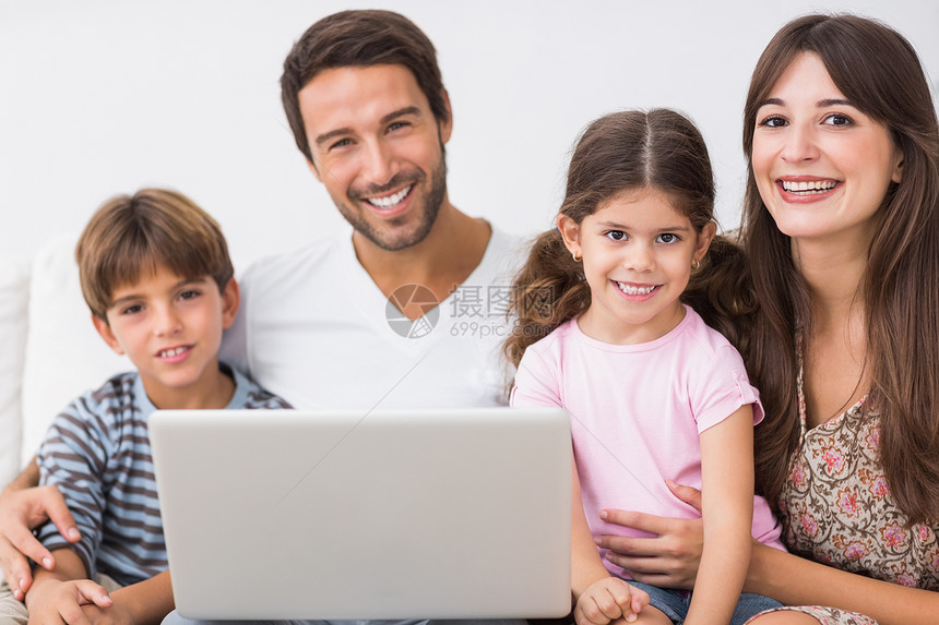 带笔记本电脑的幸福家庭混血男性快乐牙裔技术女孩头发母亲女儿客厅图片