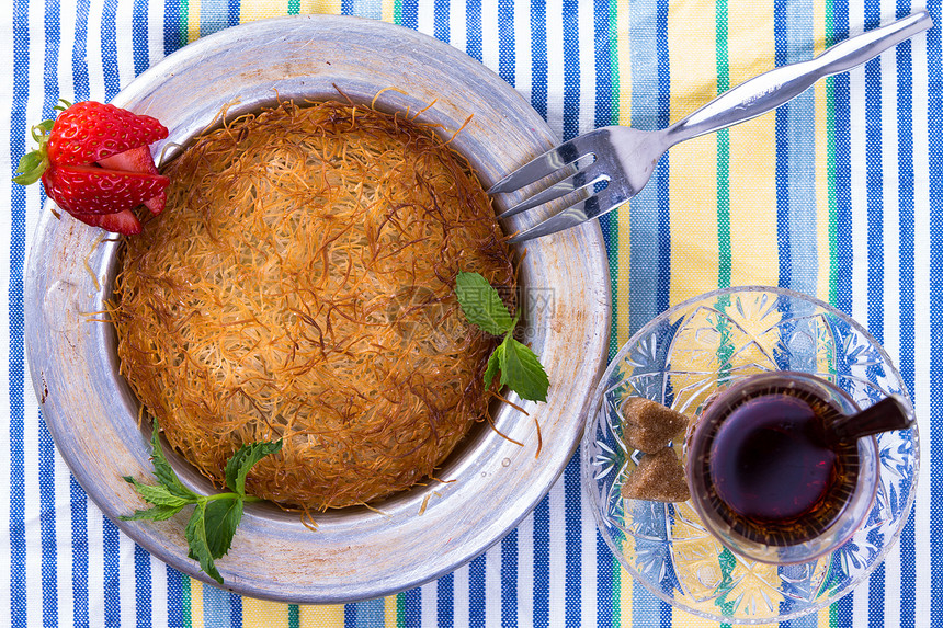 Kunefe与土耳其热茶黄油午餐美食面包食物树叶烘烤糖浆盘子薄荷图片
