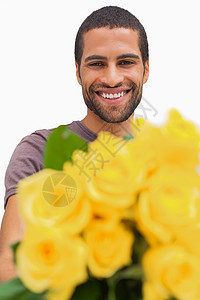 英俊的男人提供一堆黄色的玫瑰花朵高清图片素材