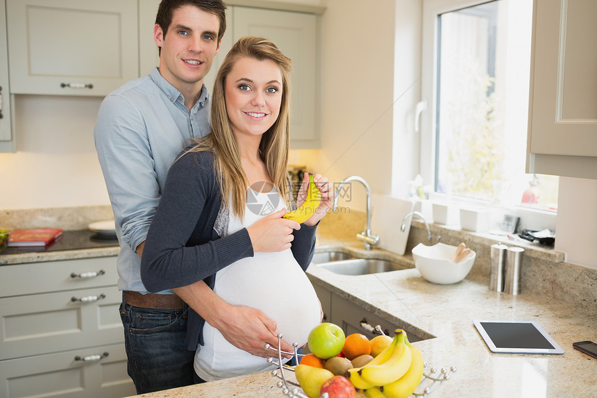 男人拥抱怀着香蕉的怀孕妻子图片