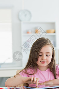 使用药片的小女孩家庭平板成人桌子厨房女孩房子微笑触摸屏铅笔背景图片