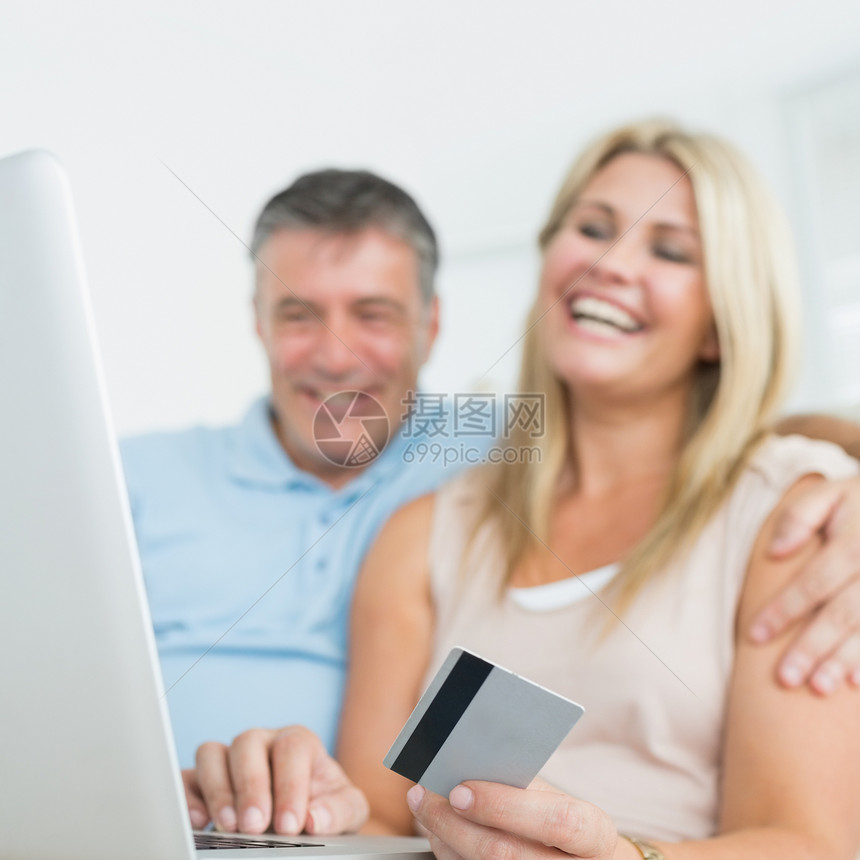 两人在沙发上用笔记本电脑在线购物图片