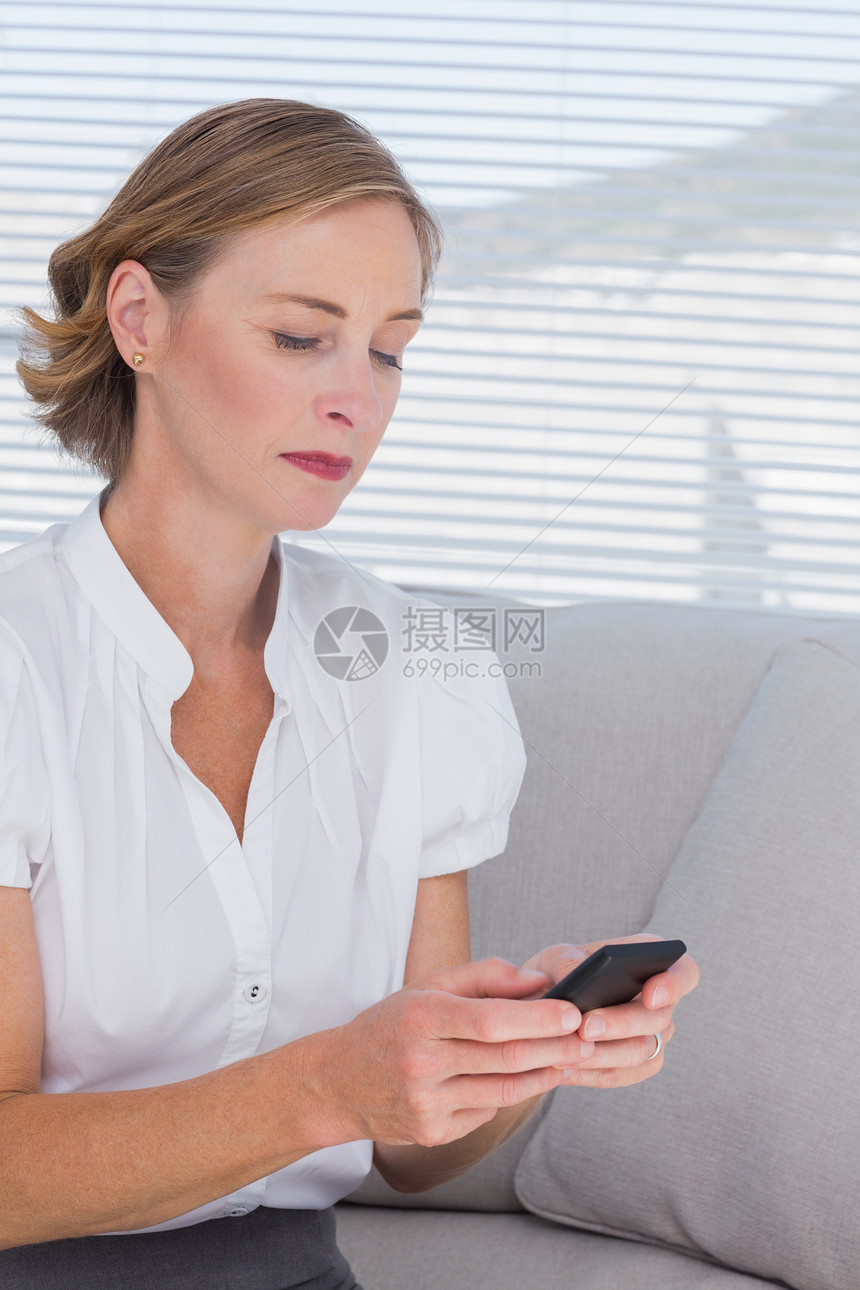 女商务人士在看她的手机时办公室女士人士女性职员金发女郎衬衫电话拨号商务图片