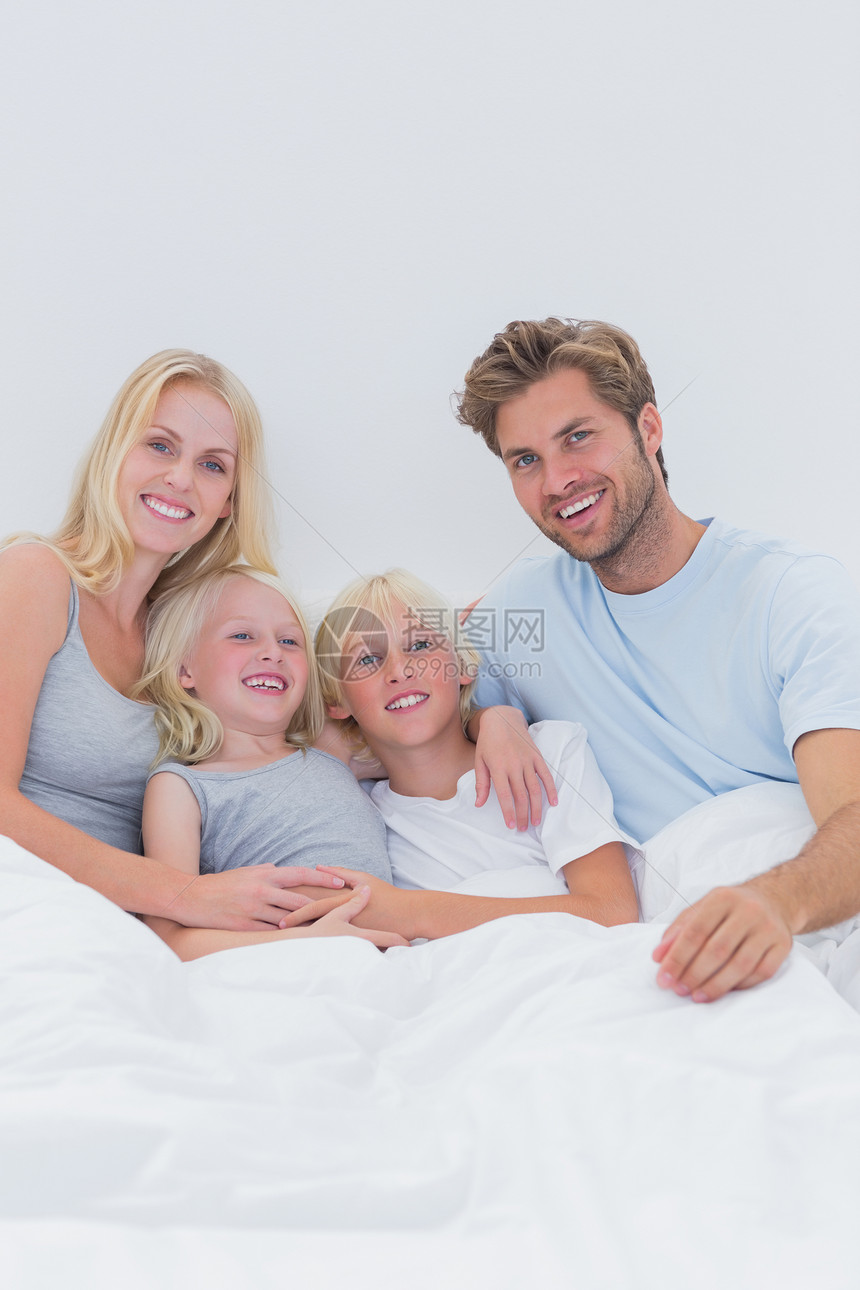 幸福家庭躺在床上的肖像快乐男性女性孩子亲密感金发坐垫公寓房子卧室图片