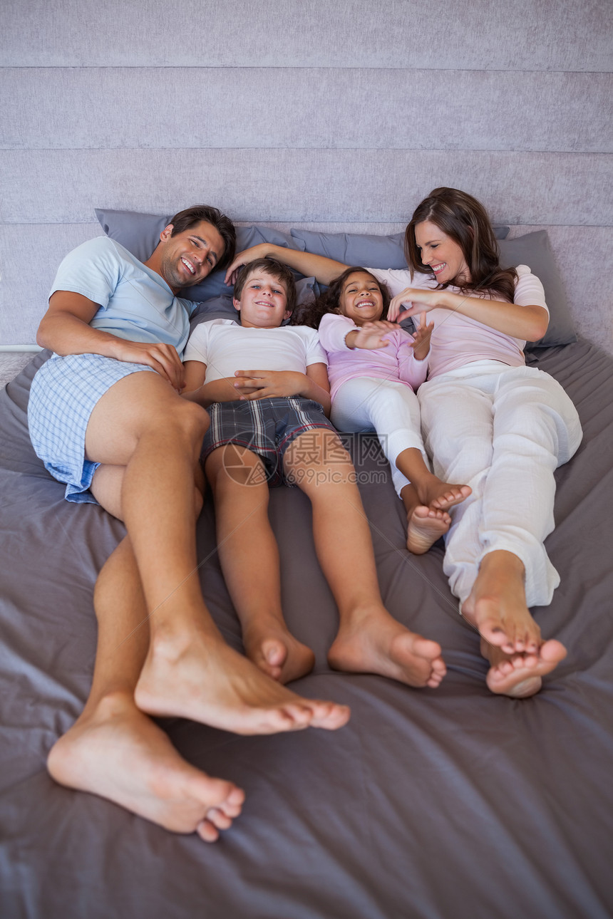 幸福的一家人一起躺在床上羽绒被感情卧室男人女性混血父亲住所女士情怀图片
