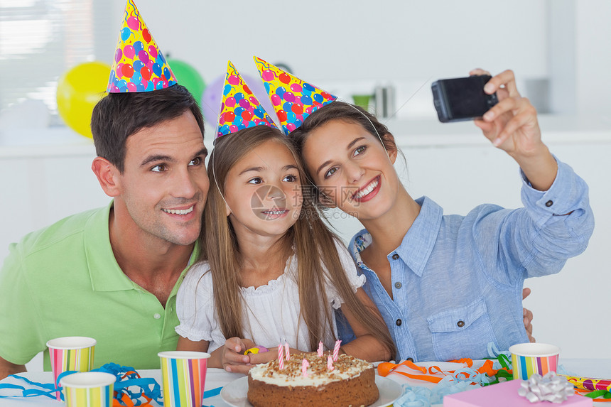 女人在生日派对上拍她家人的相片父亲男人闲暇房子生日蛋糕蜡烛孩子快乐混血飘带图片