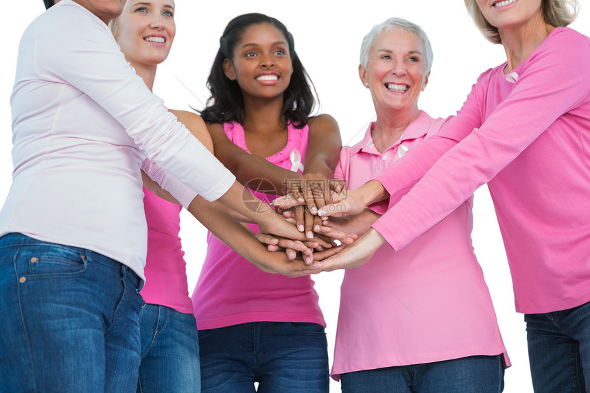 穿着乳癌丝带的快乐妇女们手牵手在一起图片