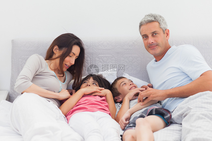 躺在床上的幸福家庭儿子公寓头发互动短发母亲坐垫父亲卧室孩子图片