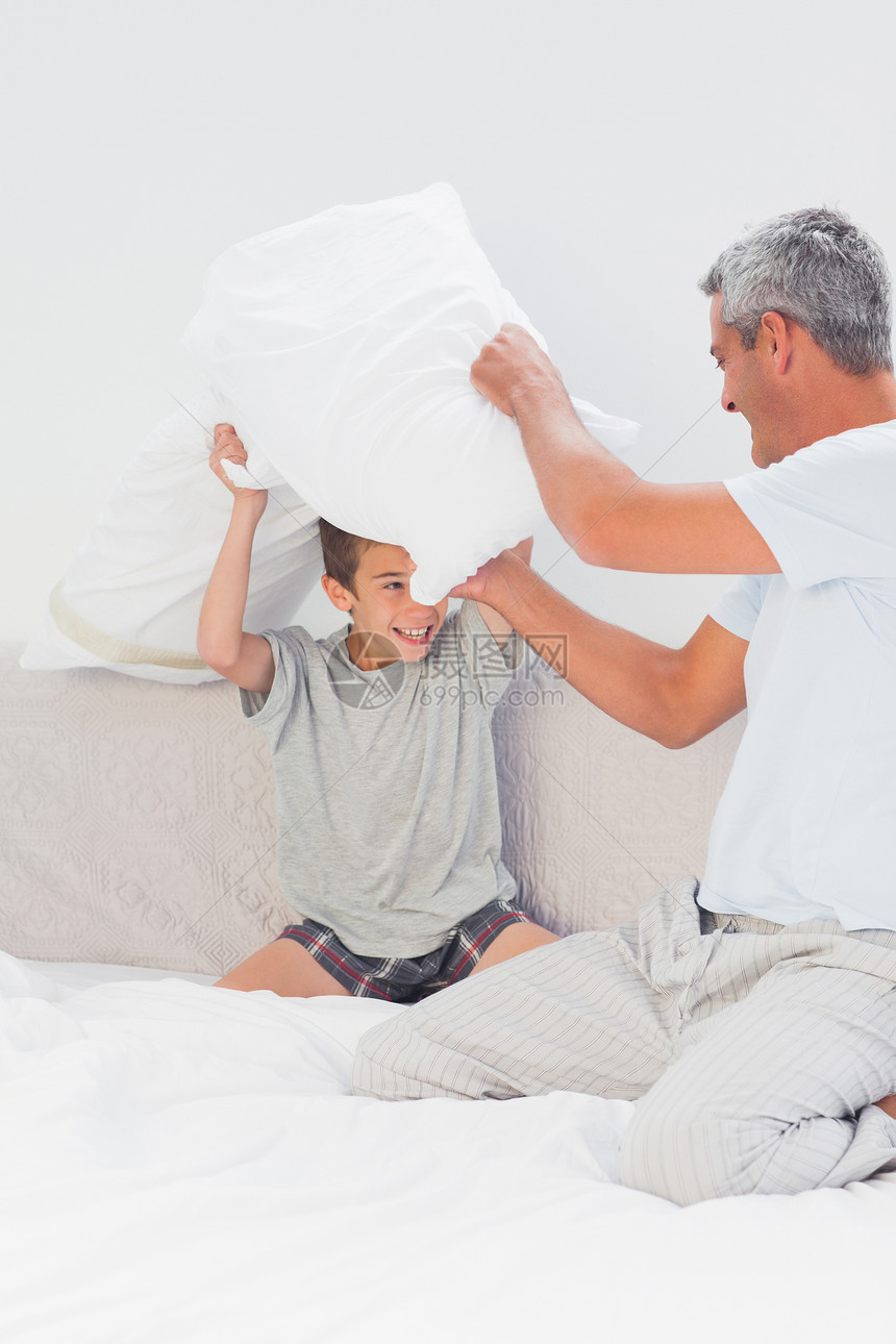 父子在床上与枕头并肩作战图片