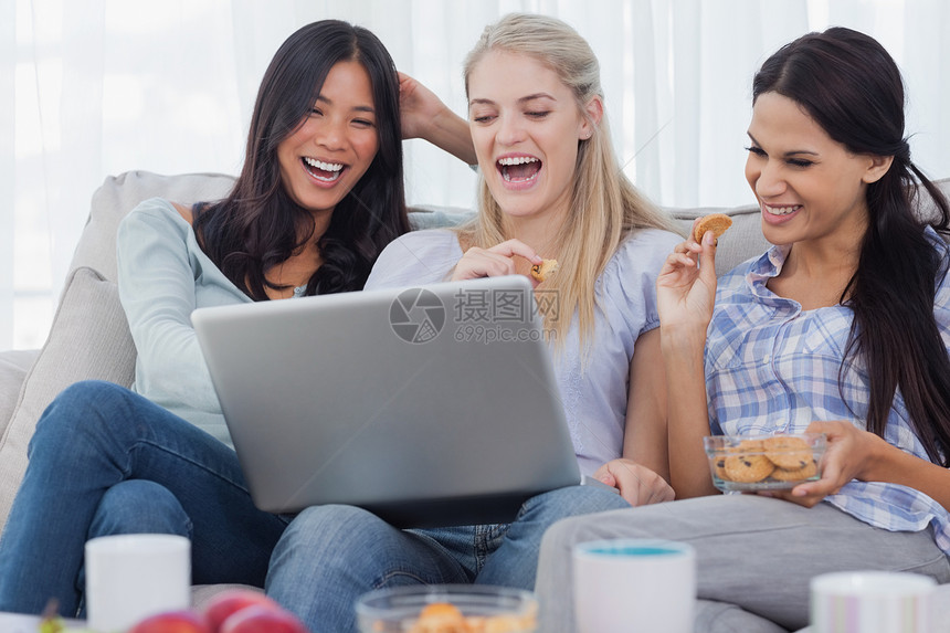 笑笑的朋友们一起看笔记本电脑和吃饼干图片