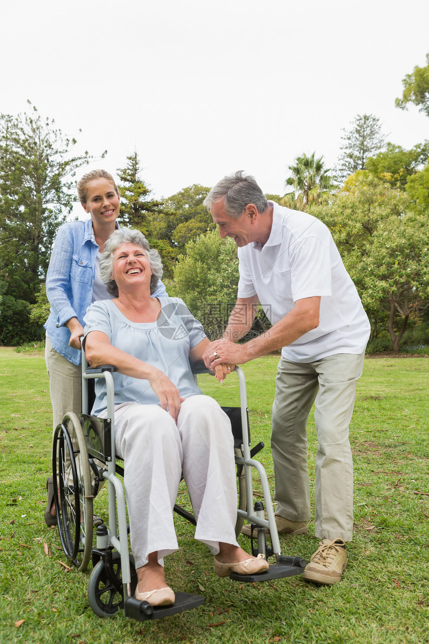 与丈夫和女儿坐轮椅的退休妇女图片