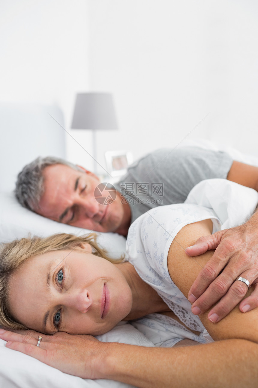 金发美女在丈夫睡着时 笑着对着镜头微笑图片