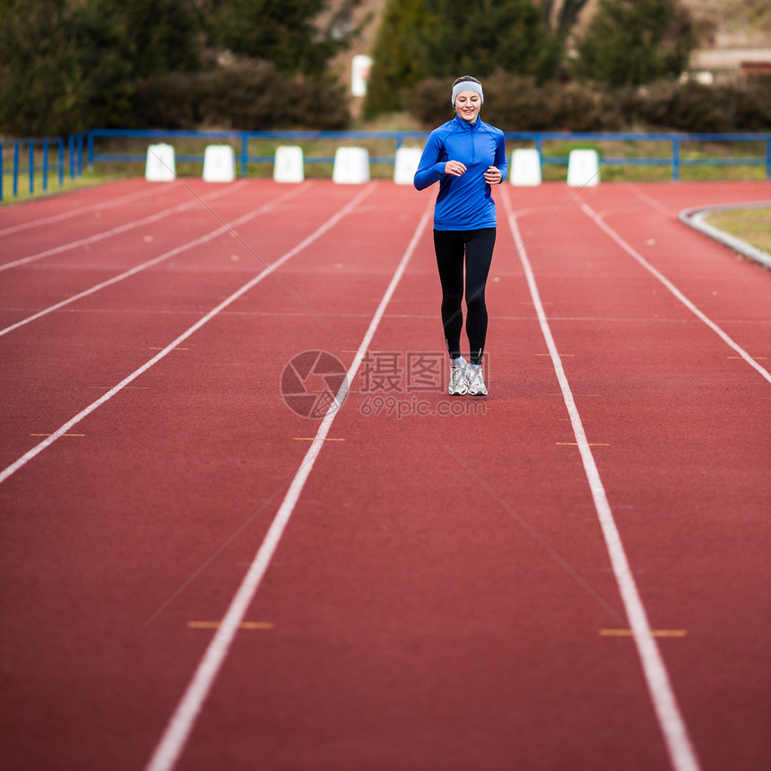 年轻妇女在赛场和田径体育场跑步蓝色闲暇赛跑者慢跑者运动女性运动装快乐训练肌肉图片