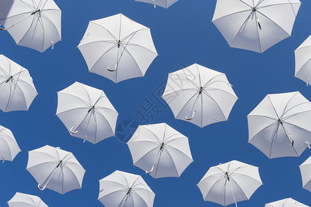蓝色天空上的白雨伞阳伞反光板季节性天气遮阳棚下雨太阳工作室气象白色背景图片