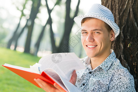 年轻人在读一本书教育学士眼镜花园中学学校幸福男性成人青年学习高清图片素材