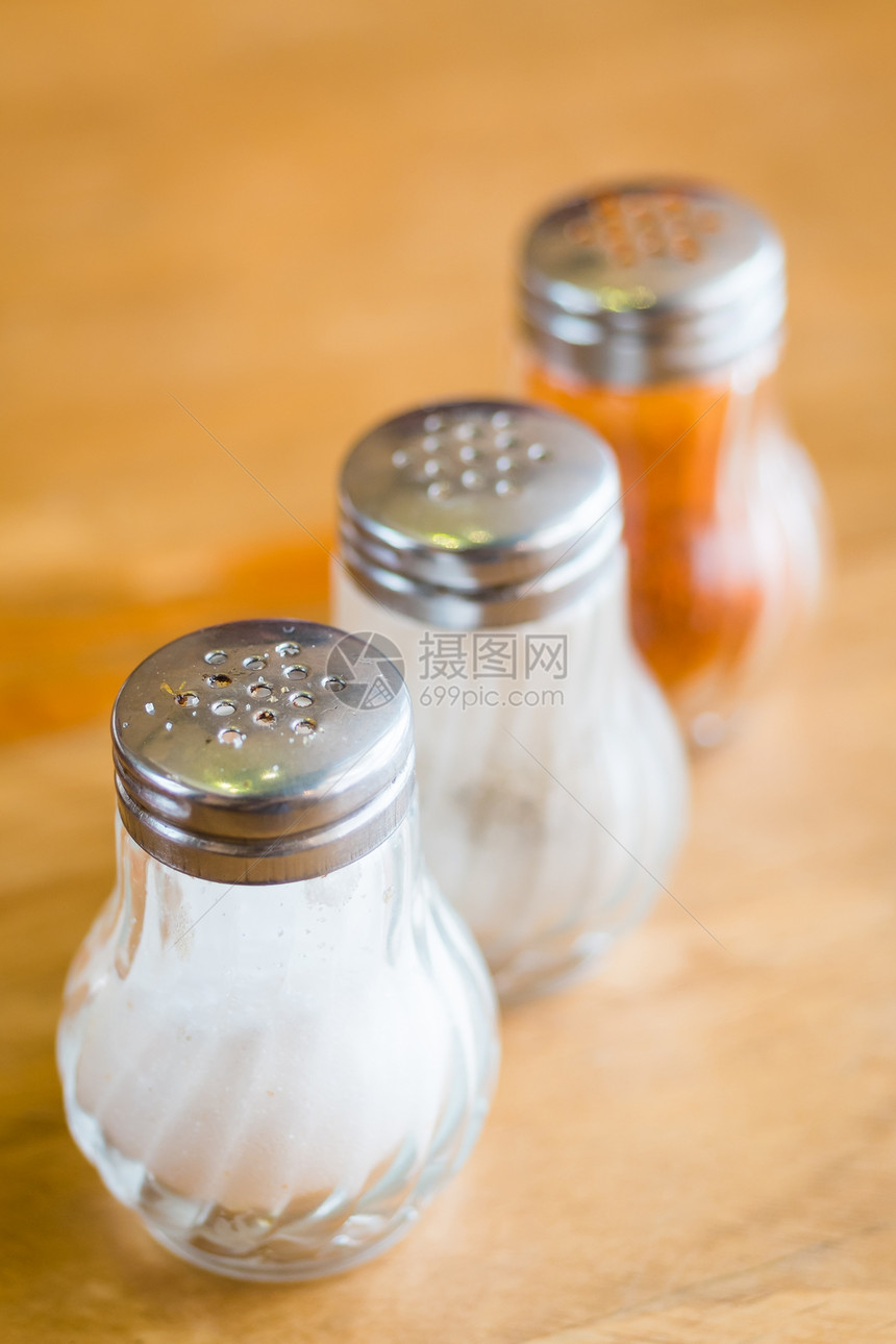 和在木桌上的摇摇玻璃瓶中的胡椒调味早餐餐厅摇床厨房烹饪不锈钢味道午餐桌子图片