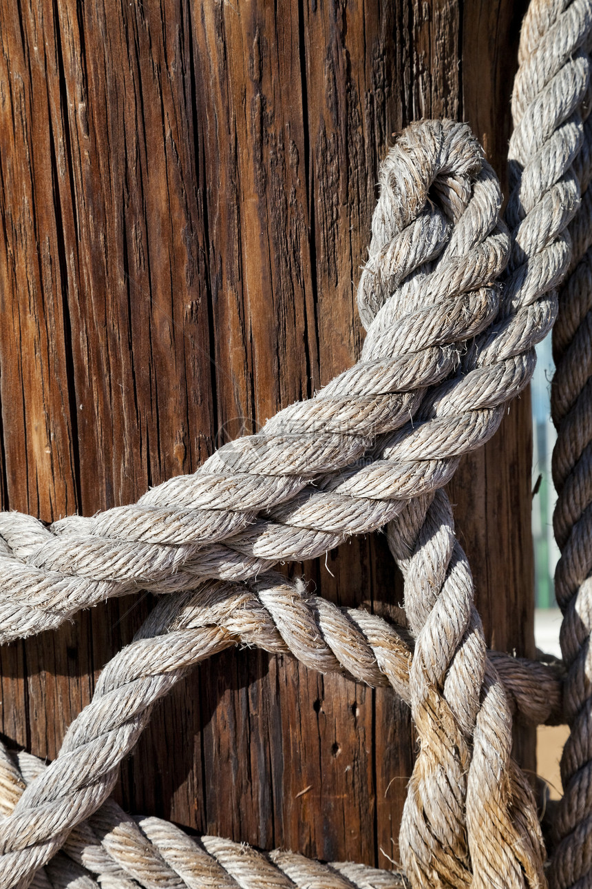 木柱上的吊灯海洋航行绳索游艇缆绳编织领带力量索具线圈图片