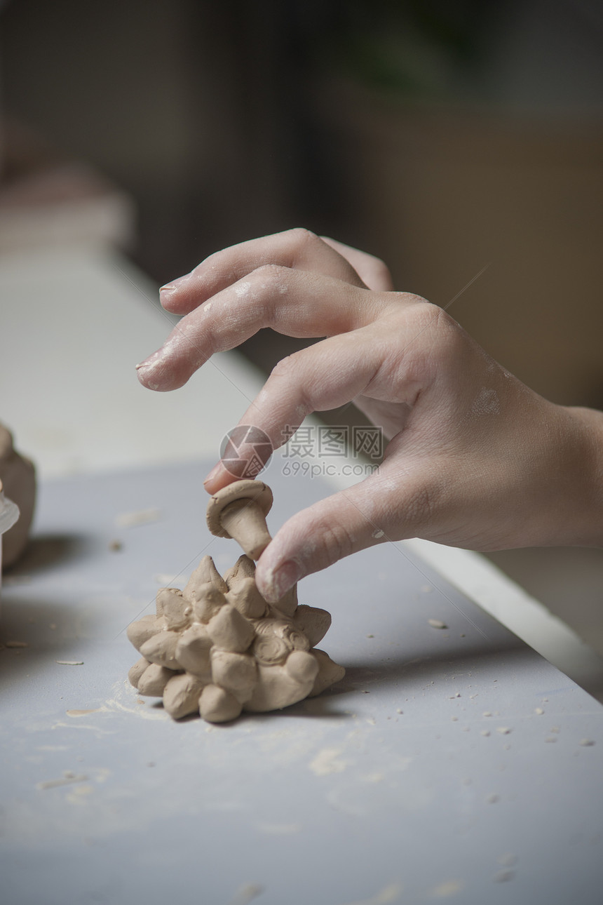 女孩用泥土做玩具纺纱拇指孩子文化工艺创造力陶瓷设计师商业陶器图片