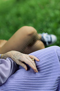 老年人手草地祖母团结智慧女性绿色双手青少年人类祖父母背景图片