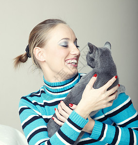 笑着的猫玩猫游戏女性微笑女士动物脊椎动物喜悦乐趣享受闲暇友谊背景