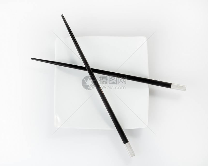 在白色背景上被孤立的板块上的筷子盘子餐具图片