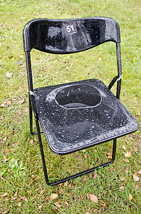 雨后在公园草坪上放着塑料椅黑色的高清图片素材