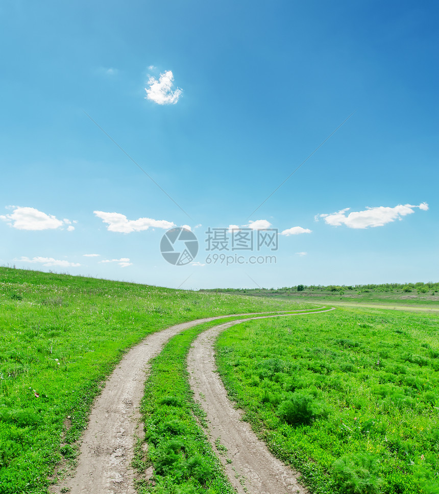 绿地上的肮脏道路阳光土地蓝色小路国家晴天场地环境风景天空图片