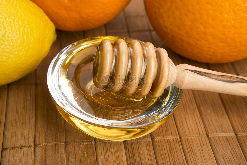 含柠檬和橙子水果的新鲜蜂蜜食物甜点生活方式黄色早餐玻璃健康饮食勺子餐具美食家图片