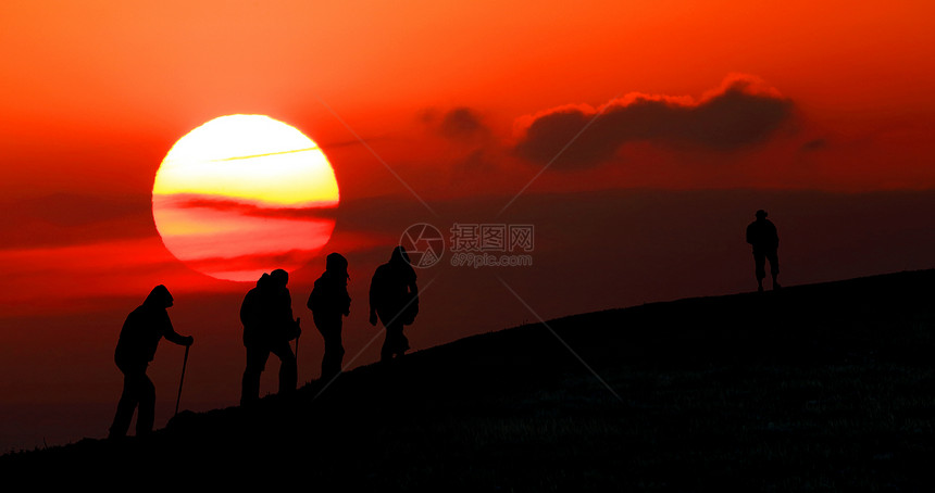 一群游客在日落时乘车到山上图片