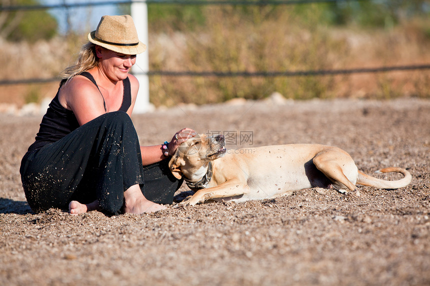 带着她的狗坐在户外的金发微笑的金发女子女士朋友闲暇快乐女性友谊场地成人晴天幸福图片