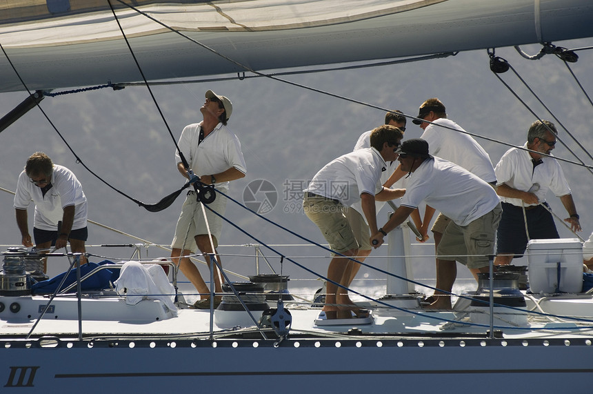乘游艇边观的船员海岸线棕榈航海人员帆船滑轮绞盘合作中年人甲板图片