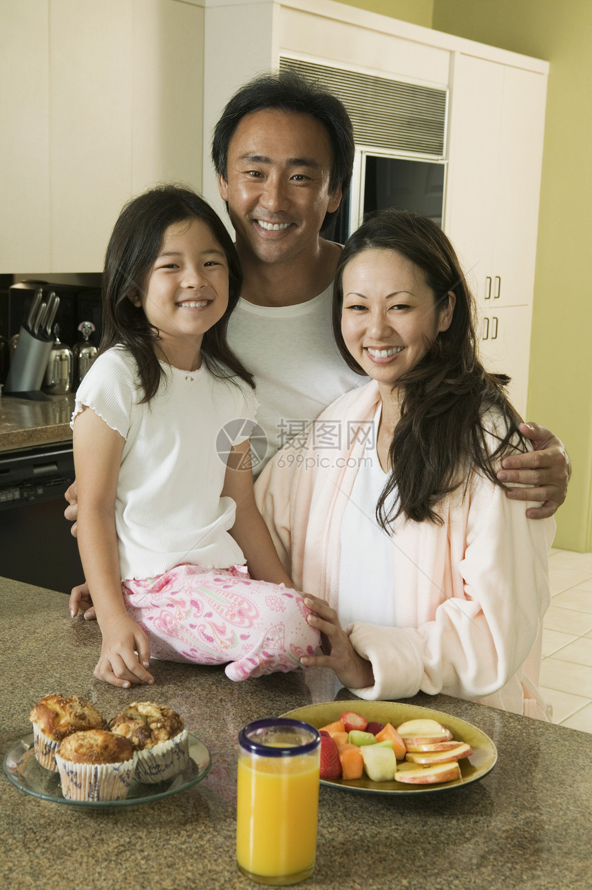 一个亚洲家庭的肖像 家里的厨房桌边吃着早饭图片